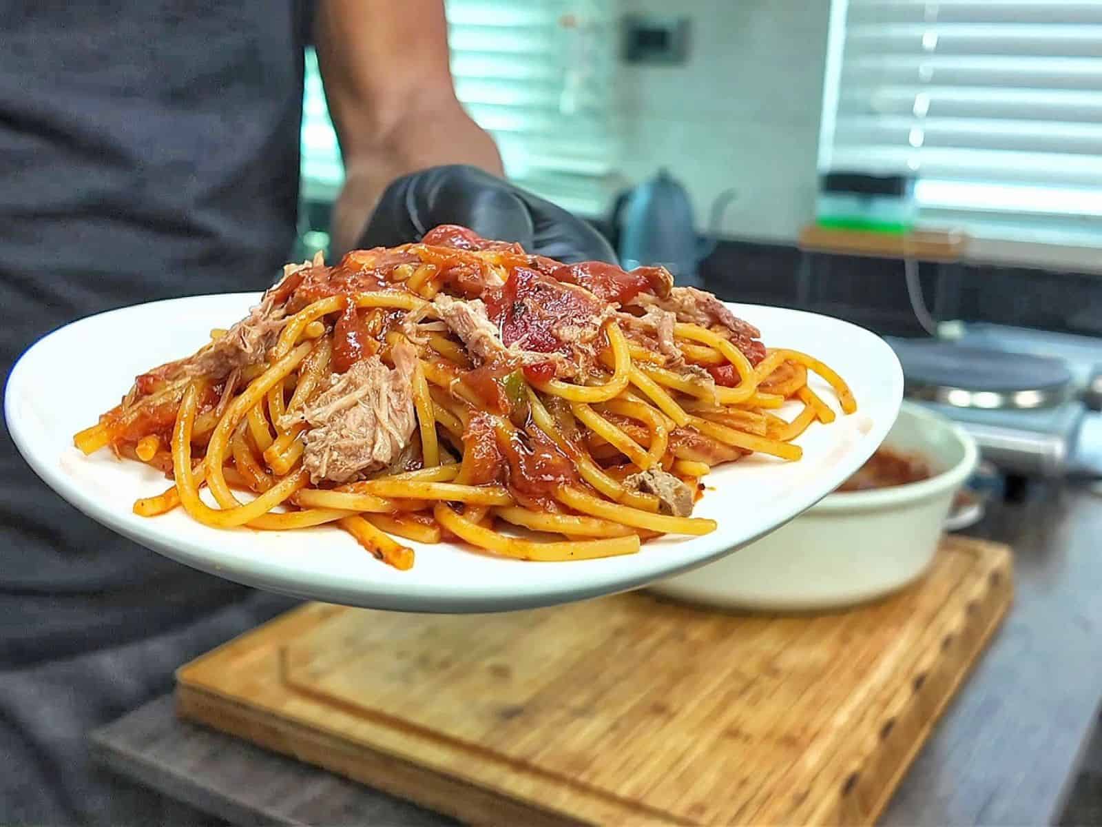 Close-up of BBQ Pulled Pork Spaghetti featuring shredded pork, spaghetti noodles, diced tomatoes, and a thick, smoky barbecue tomato sauce.