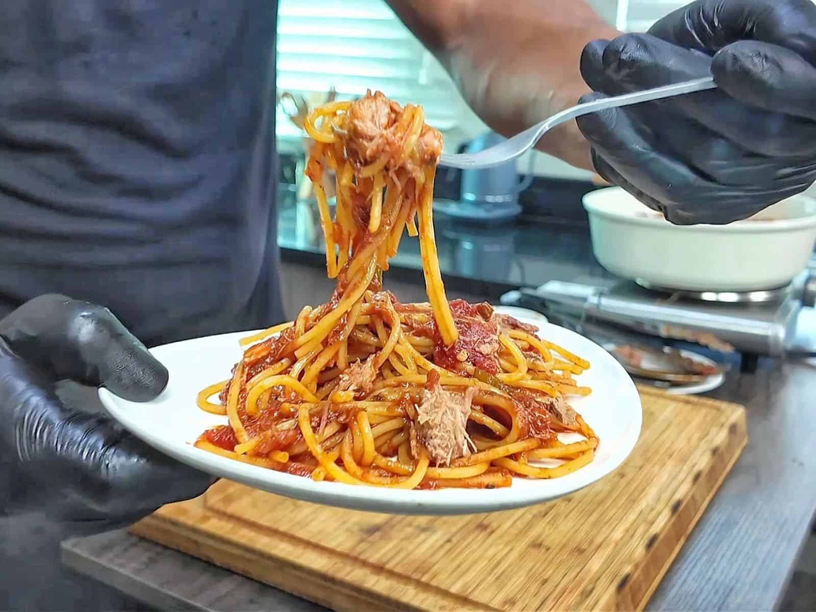 Close-up of BBQ Pulled Pork Spaghetti featuring shredded pork, spaghetti noodles, diced tomatoes, and a thick, smoky barbecue tomato sauce.