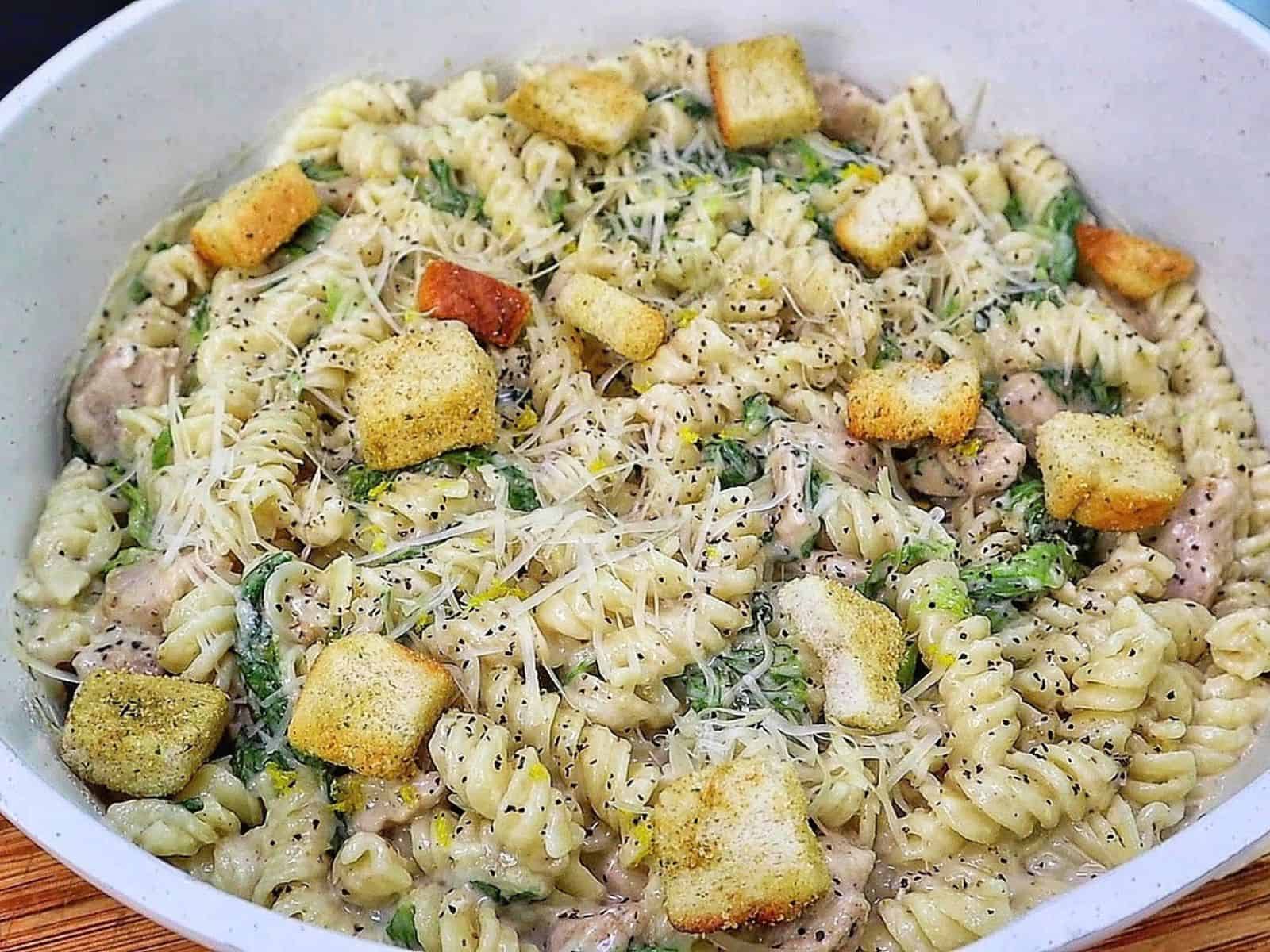Creamy One Pot Chicken Caesar Pasta with tender seasoned chicken, penne pasta, Parmesan cheese, Caesar dressing, chopped romaine and crunchy croutons.
