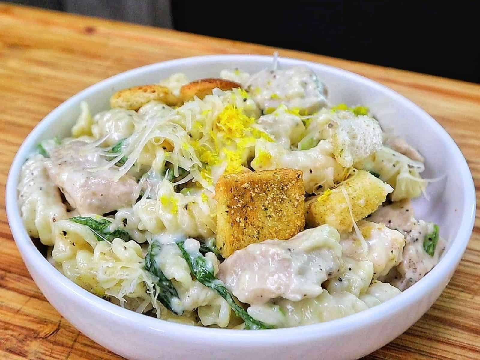 Creamy One Pot Chicken Caesar Pasta with tender seasoned chicken, penne pasta, Parmesan cheese, Caesar dressing, chopped romaine and crunchy croutons.