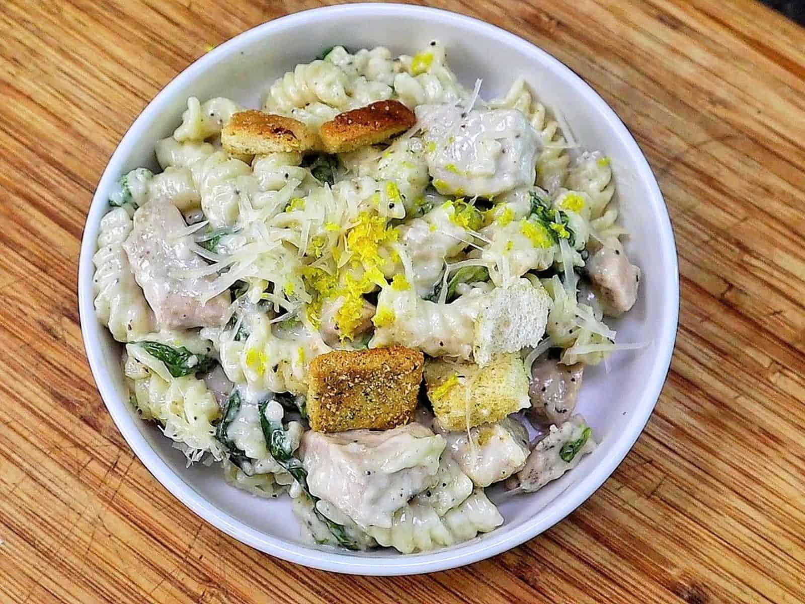 Creamy One Pot Chicken Caesar Pasta with tender seasoned chicken, penne pasta, Parmesan cheese, Caesar dressing, chopped romaine and crunchy croutons.
