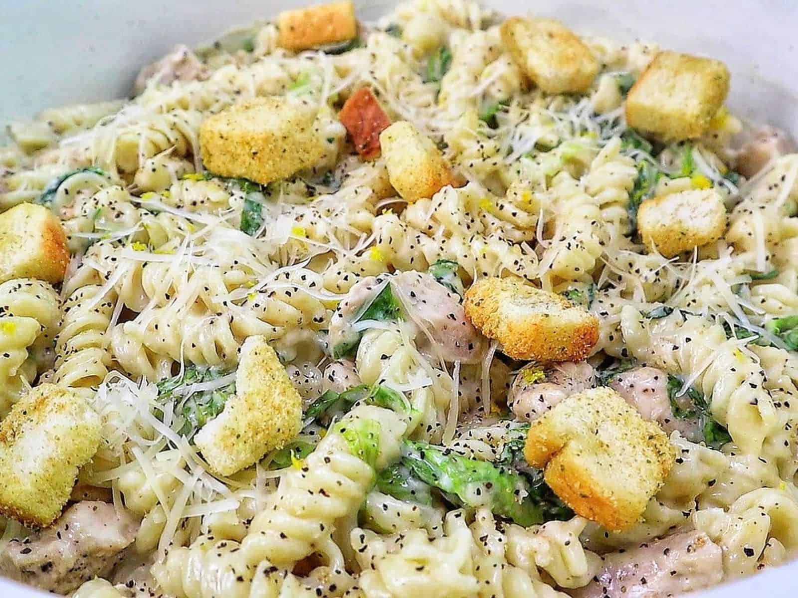 Creamy One Pot Chicken Caesar Pasta with tender seasoned chicken, penne pasta, Parmesan cheese, Caesar dressing, chopped romaine and crunchy croutons.