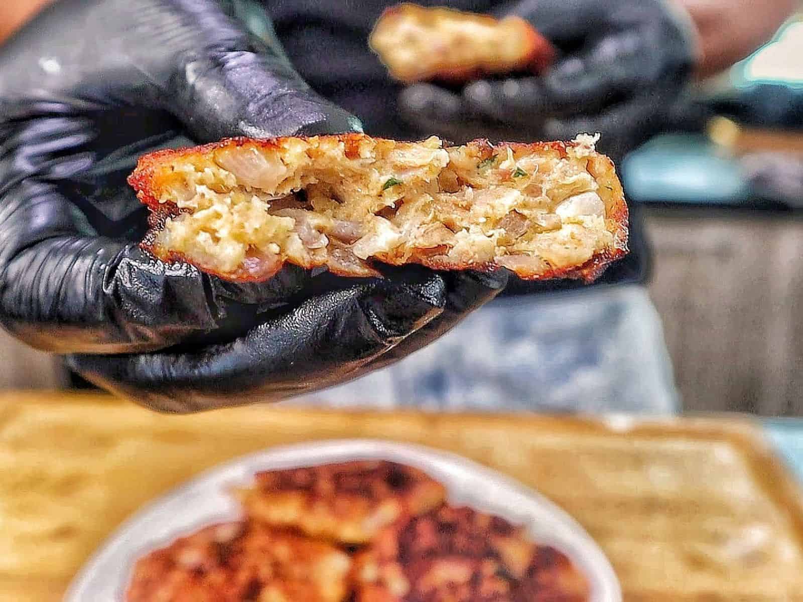 Crispy homemade tuna patties pan-fried until golden brown with chopped onions and herbs, stacked on a white plate.